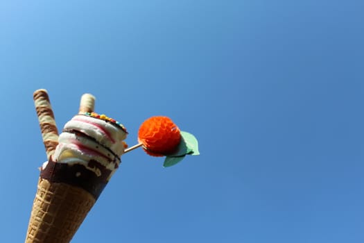 The picture shows an ice cream cone in front of the blue sky.