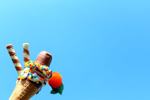 The picture shows an ice cream cone in front of the blue sky.