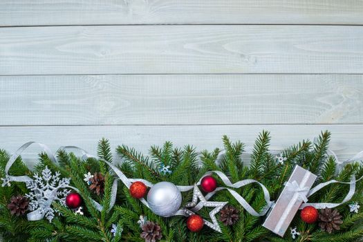 Christmas new year flat lay bauble decor and fir branches on white toned natural wooden plank background texture provence style with copy space for text