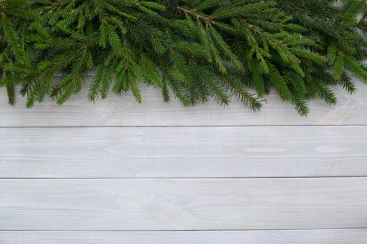 Christmas background with fir branches on white toned natural wooden plank background texture provence style for copy space for text