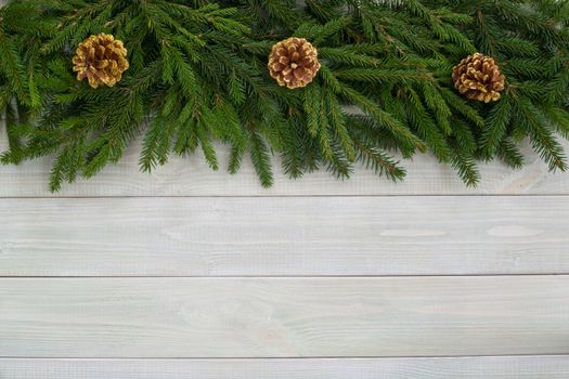 Christmas background with fir branches and cones on white toned natural wooden plank background texture provence style for copy space for text