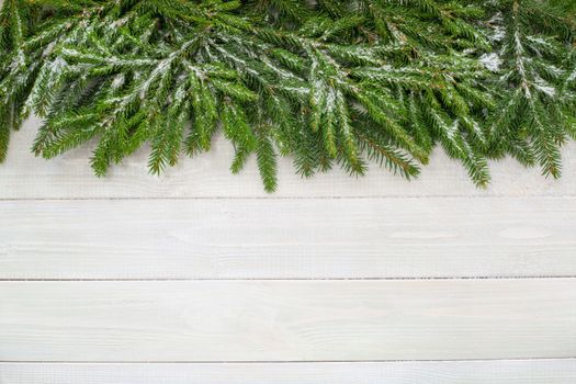 Christmas background with fir branches and snow on white toned natural wooden plank background texture provence style for copy space for text