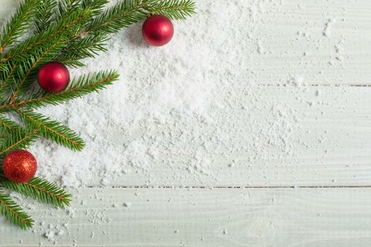 Light white toned natural wooden plank background with fir and christmas decorative baubles