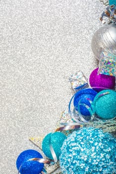 Christmas decoration of colorful glitter balls on silver glitter background with copy space for text new year card concept