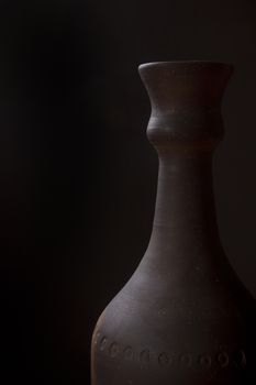 Clay bottle for wine on a black background