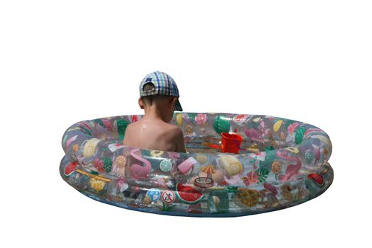 A boy in a cap with his back to the viewer in a colored plastic pool with water on a white background.