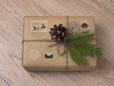 Christmas or New Year gift boxes wrapped in kraft paper with fir branch on wooden background.