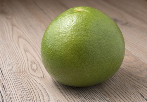 Whole Green Sweetie on wooden background. Close up view.