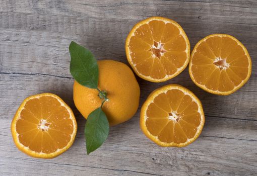 Fresh ripe tangerines with leaves on a wooden background. Top view.
