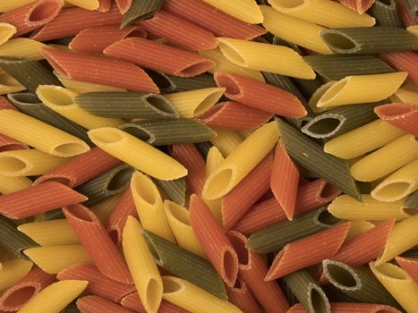 Tri-color penne pasta. Tomato, spinach and wheat pastas. Top view.