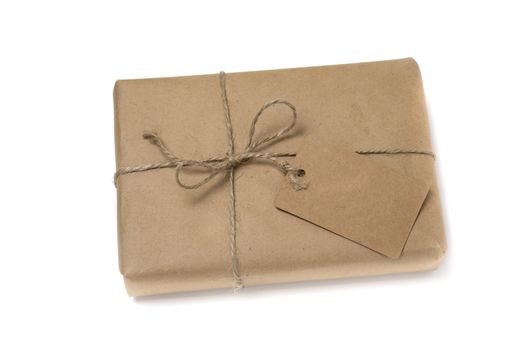 Christmas or New Year gift box wrapped in kraft paper with blank gift tag isolated on white background
