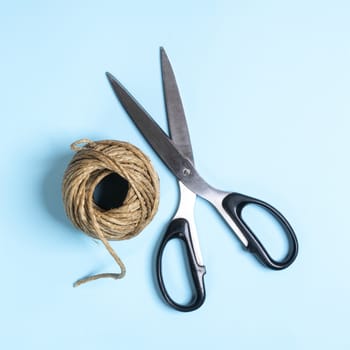 a ball of string and a pair of scissors on a white surface