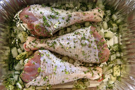 Turkey leg on steel board with herbs