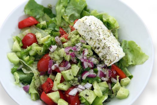 Greek salad with lettuce, tomatoes, cucumbers, peppers, red onion, oregano and feta