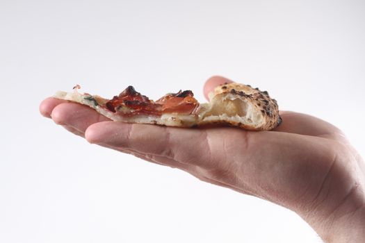 close up on the hand holding the slice of sliced pizza