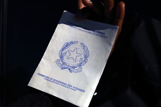 Caserta, Italy - September 27, 2019: A migrant shows his residence permit for foreigners