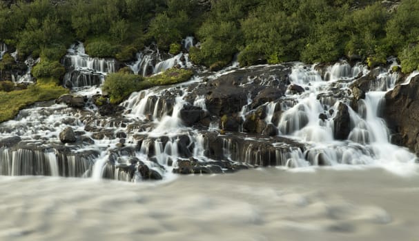 The waterfall Hraunfossar in the land of Gilsbakki at the edge of Hallmundarhraun.