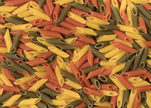 Tri-color penne pasta. Tomato, spinach and wheat pastas. Top view.