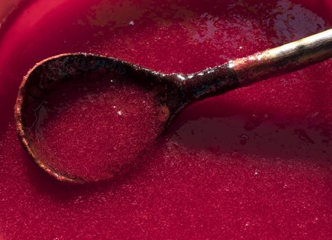 Making juice from viburnum berries at home. Process of making red sweet syrup. Close-up.