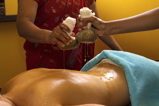   indian doctors doing traditional ayurvedic oil back massage