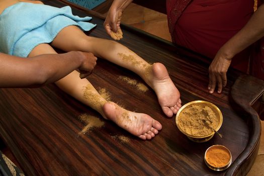   indian doctors doing traditional ayurvedic oil foot massage