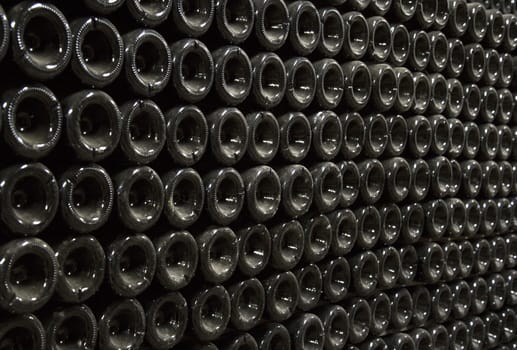 Close up image of champagne bottles in a wine rack while they ferment.