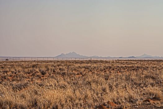 A fence line is the only indication that the Kalahari Desert in Southern Namibia is also extensive farmland