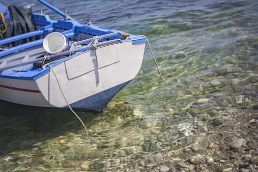 Wooden boat detail in trasparent sea in Sicily