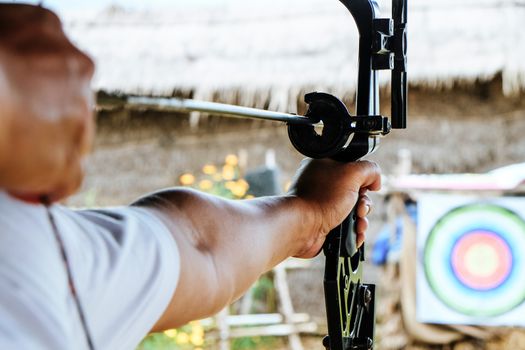 Archer holds his bow aiming at a target
