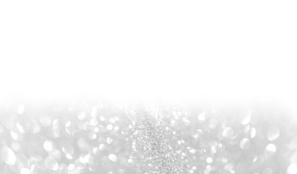 Silver festive glitter background with defocused lights , white copy space