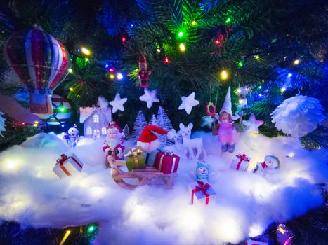 Beautiful glowing christmas tree with many present boxes and decor on snow