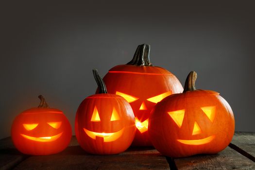 Halloween pumpkin head jack o lantern and candles on wooden background
