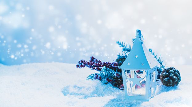 Burning candle in lantern and christmas decoration on snow
