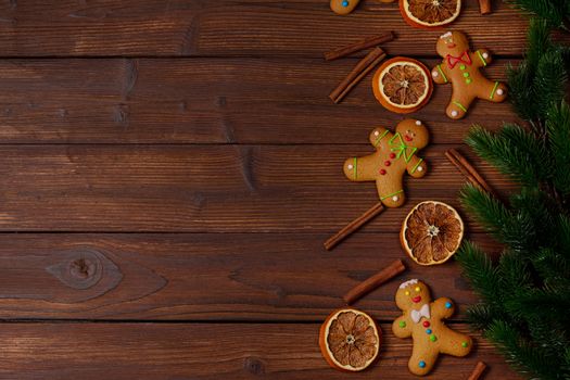 Christmas food frame. Gingerbread cookies, spices and fir branches on wooden background with copy space