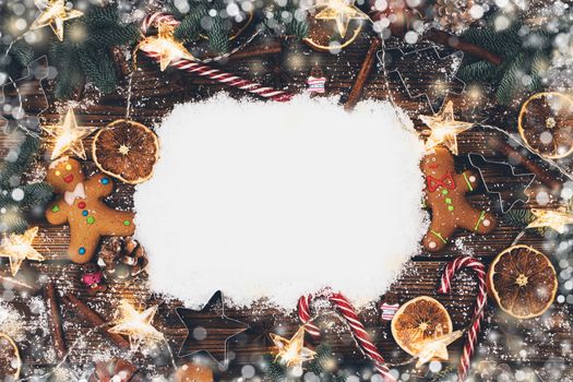 Christmas food frame. Gingerbread cookies, spices and decorations on wooden background with copy space on snow