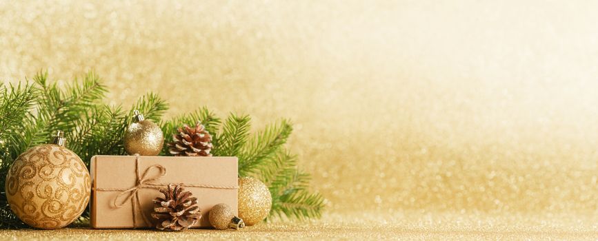 Christmas toys, decorations, present gift box wrapped in kraft paper on golden glitter background, copy space