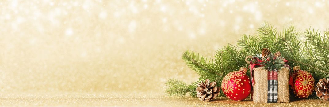 Christmas toys, decorations, present gift box wrapped in kraft paper on golden glitter background, copy space