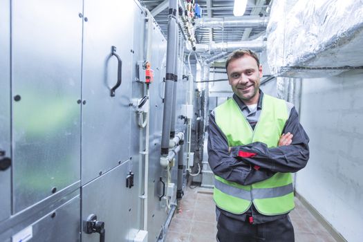 Portrait of smiling worker in electrical switchgear room of CNC plant