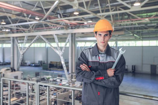 Portrait of young worker with wrench at CNC factory