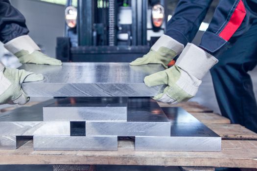 Workers taking aluminium billet at CNC machine shop