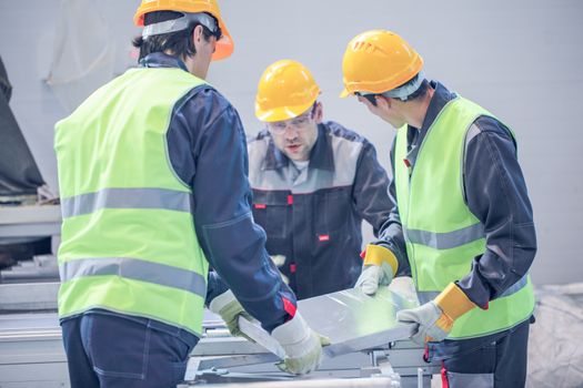 Workers taking aluminium billet at CNC machine shop