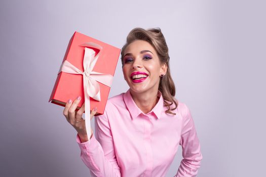 Happy beautiful funny woman holding red gift box with white ribbon