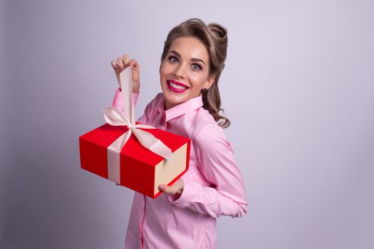 Happy beautiful funny woman open red gift box with white ribbon