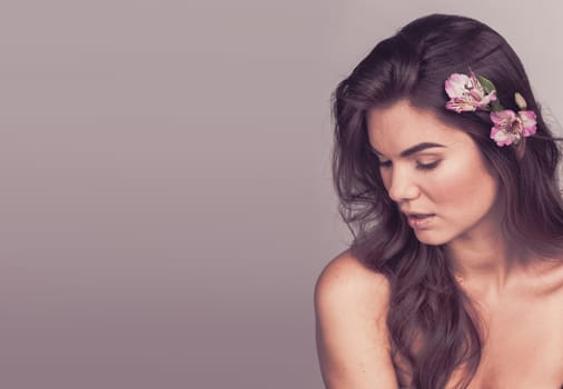 Portrait of beautiful young woman with flower in hair