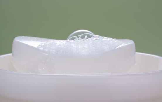 Wet white soap bar in a soap-holder