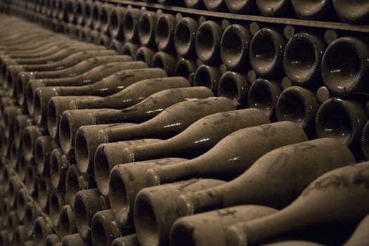 Close up image of champagne bottles in a wine rack while they ferment.