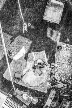 Top view of authentic builder men working with shovel during concrete cement solution mortar preparation in mixer at construction site. Black and white image.