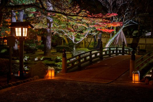 illuminated bridge in Kenrokuen garden during the red maple leaf season (momijigari), Kanazawa city, Ishikawa prefecture, Japan