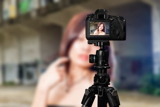 Taiwanese Chinese Vlogger posing for social media  photos viewed through back of camera