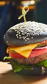 Japanese Black Burger with Cheese. Cheeseburger from Japan with black bun on dark background